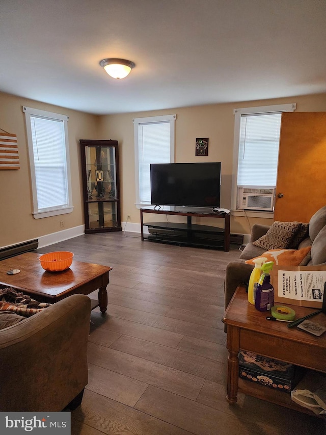 living room with cooling unit, wood-type flooring, a wealth of natural light, and a baseboard heating unit