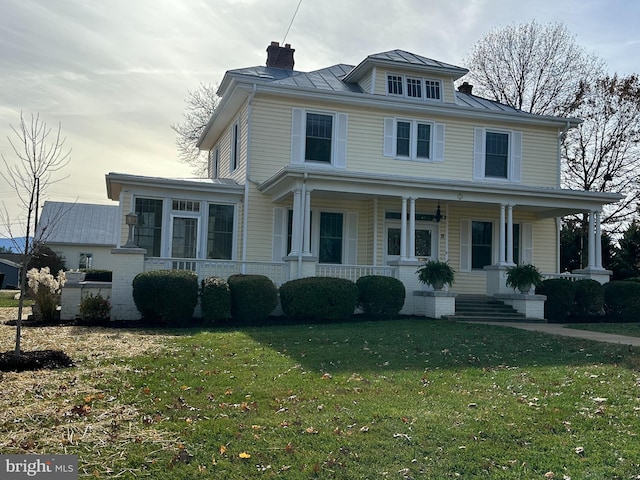 view of front of home featuring covered porch and a front lawn