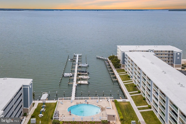 aerial view at dusk featuring a water view