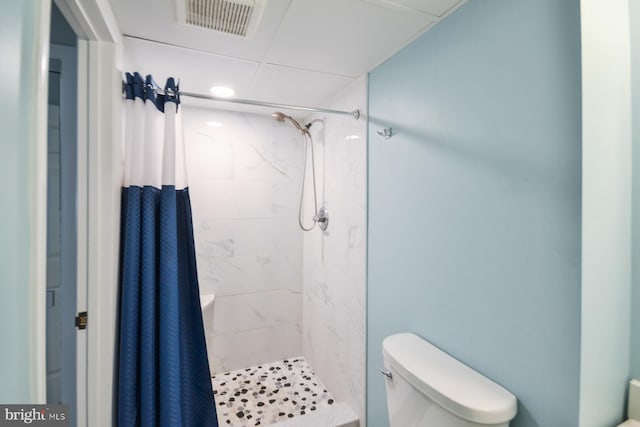 bathroom featuring a shower with curtain and toilet