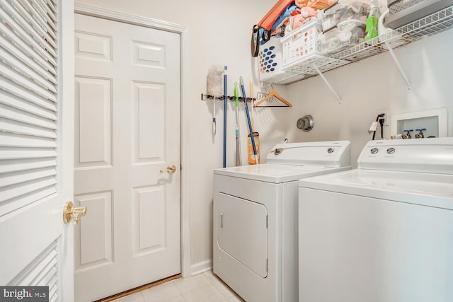 washroom with washing machine and dryer and light tile patterned flooring