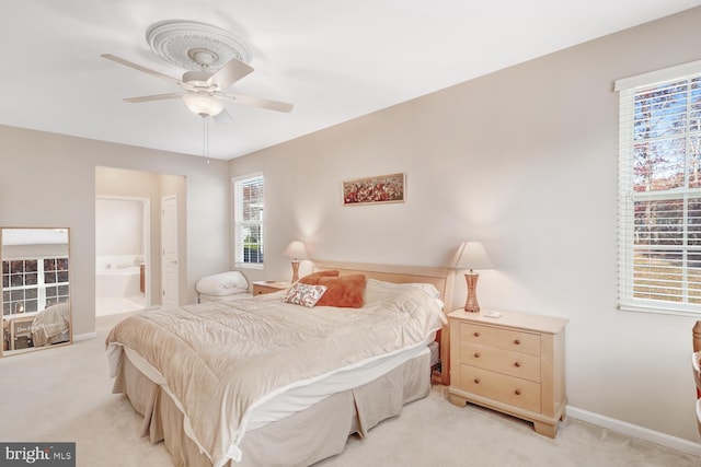 carpeted bedroom with ceiling fan and ensuite bathroom