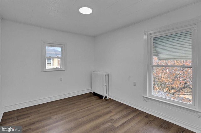 empty room featuring radiator and dark wood-type flooring