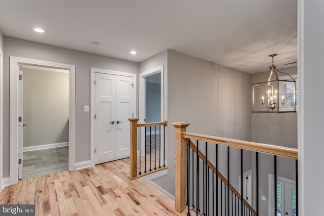 hall featuring light hardwood / wood-style flooring and a chandelier