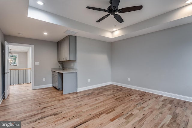 interior space featuring ceiling fan, light wood-type flooring, and sink