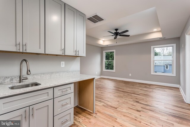 kitchen with a healthy amount of sunlight, light stone countertops, and sink