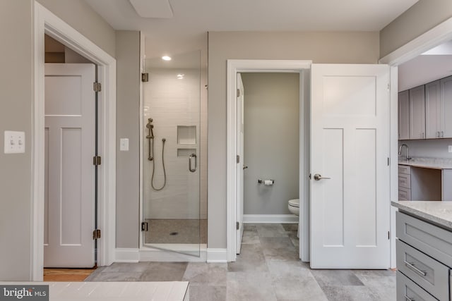 bathroom with vanity, toilet, and a shower with shower door