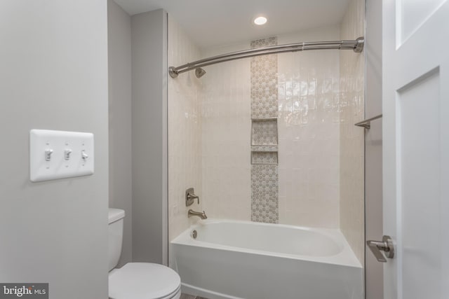 bathroom with toilet and tiled shower / bath