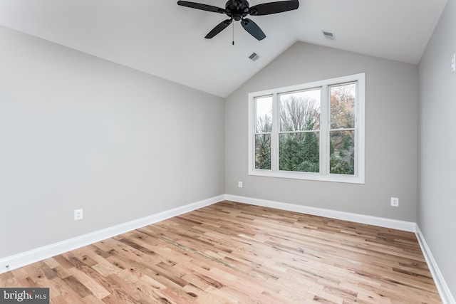 empty room with ceiling fan, vaulted ceiling, and light hardwood / wood-style flooring