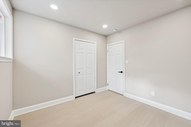 unfurnished bedroom with a closet and light hardwood / wood-style flooring