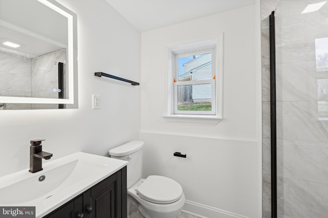 bathroom featuring tiled shower, vanity, and toilet