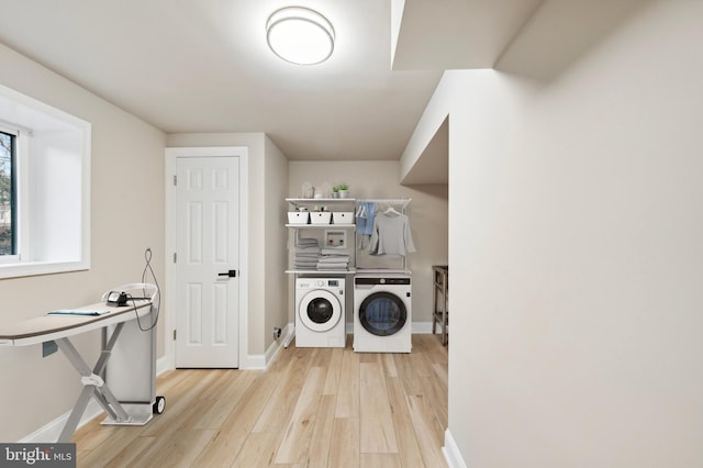 washroom with light hardwood / wood-style floors and washing machine and clothes dryer