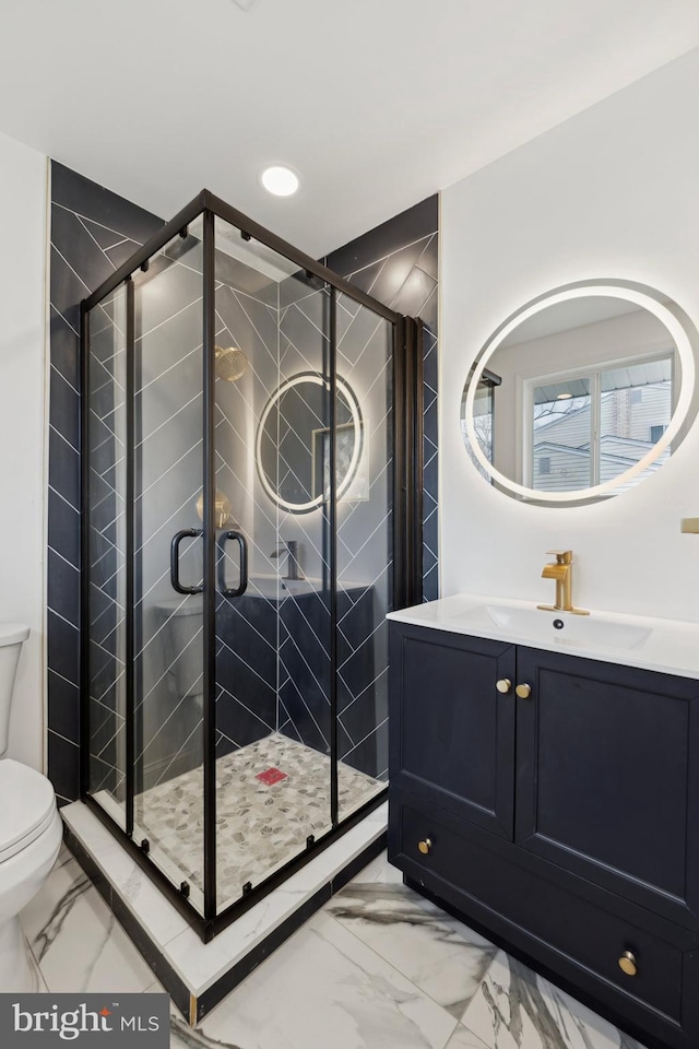 bathroom featuring vanity, toilet, and walk in shower