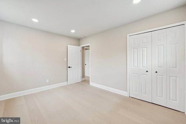 unfurnished bedroom with a closet and light wood-type flooring