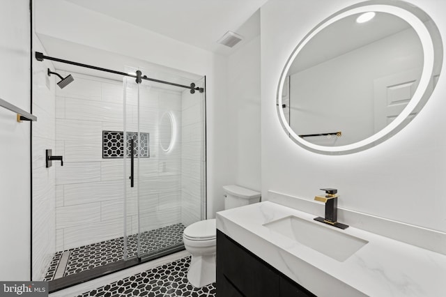 bathroom featuring vanity, a shower with shower door, and toilet