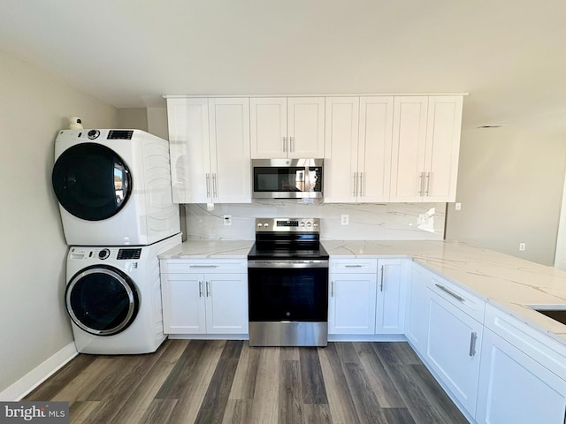 kitchen featuring white cabinetry, stacked washer and dryer, dark wood-type flooring, and appliances with stainless steel finishes