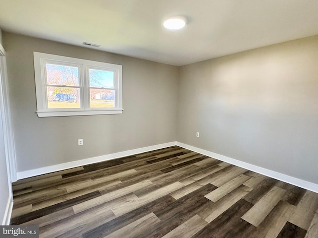 unfurnished room with dark hardwood / wood-style flooring