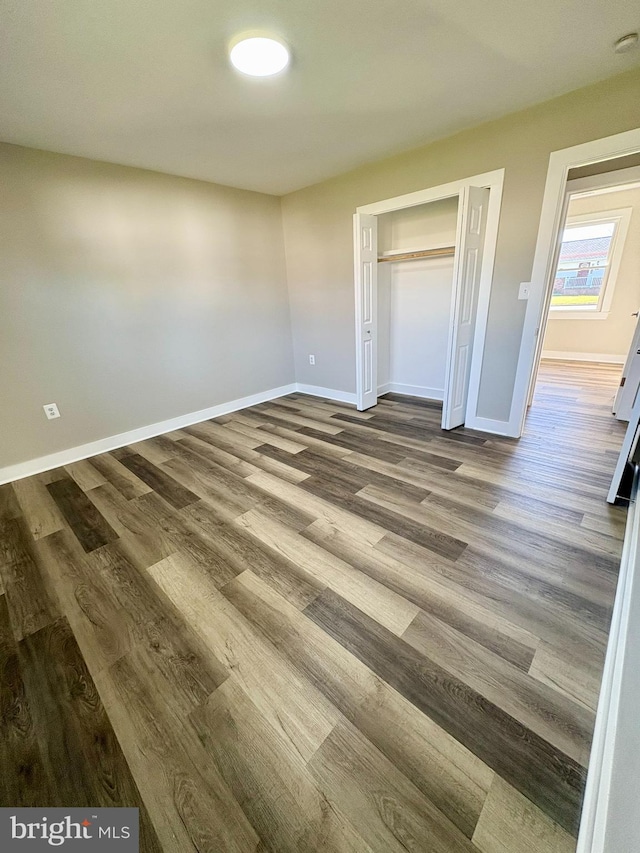 unfurnished bedroom featuring wood-type flooring and a closet