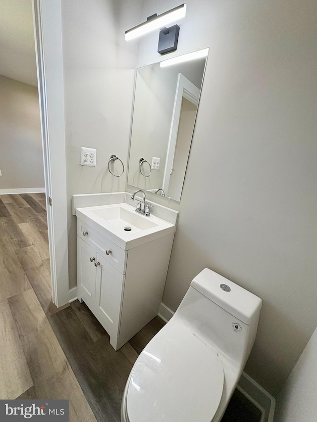 bathroom with vanity, hardwood / wood-style flooring, and toilet