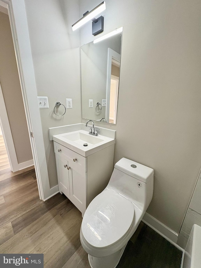 bathroom featuring wood-type flooring, vanity, and toilet