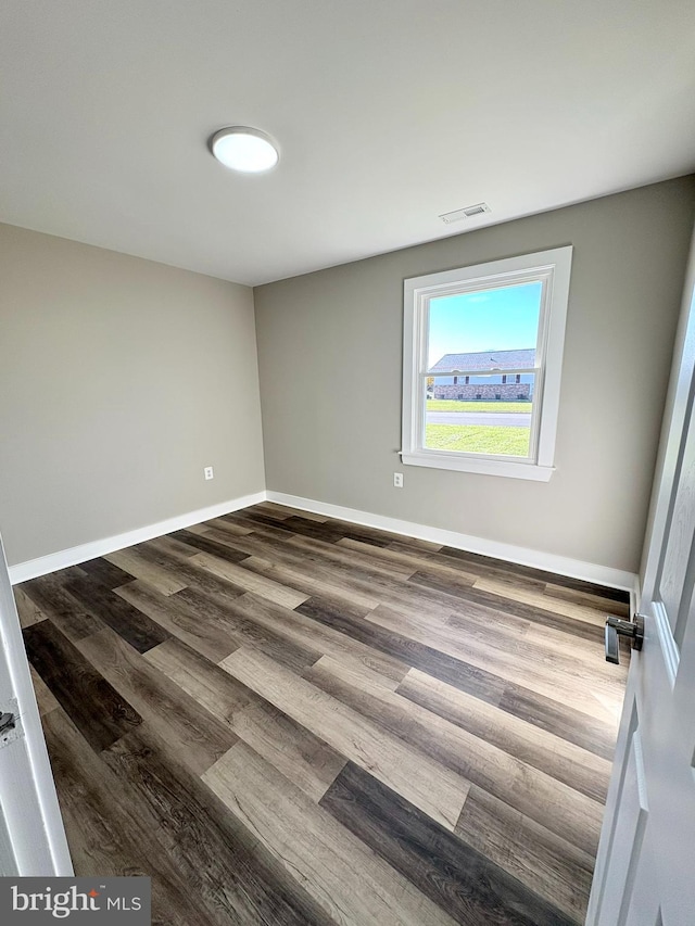 spare room with dark hardwood / wood-style flooring