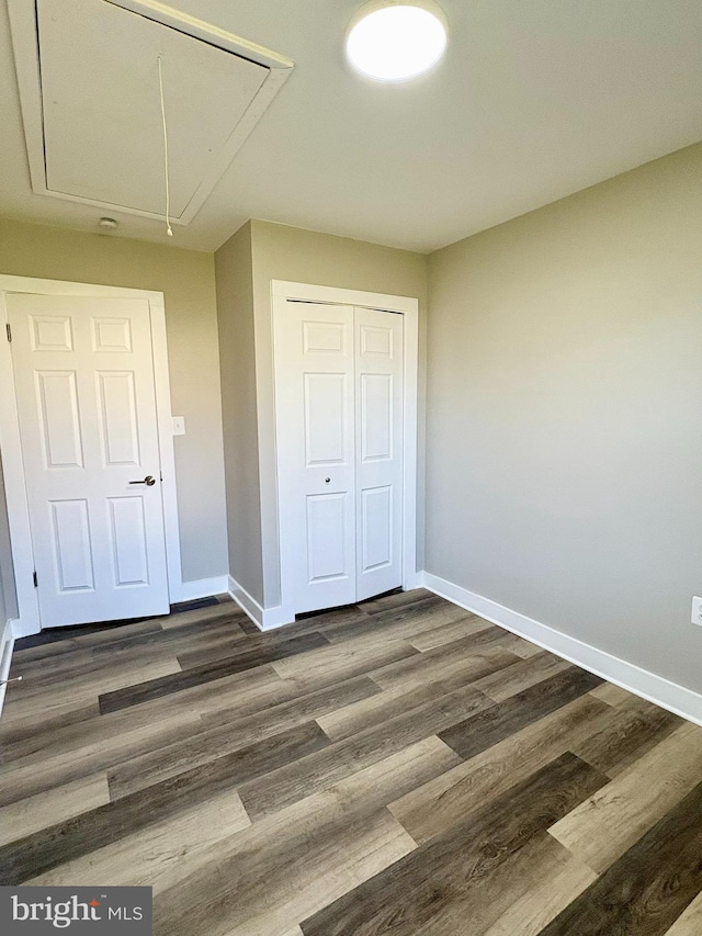 unfurnished bedroom featuring a closet and dark wood-type flooring