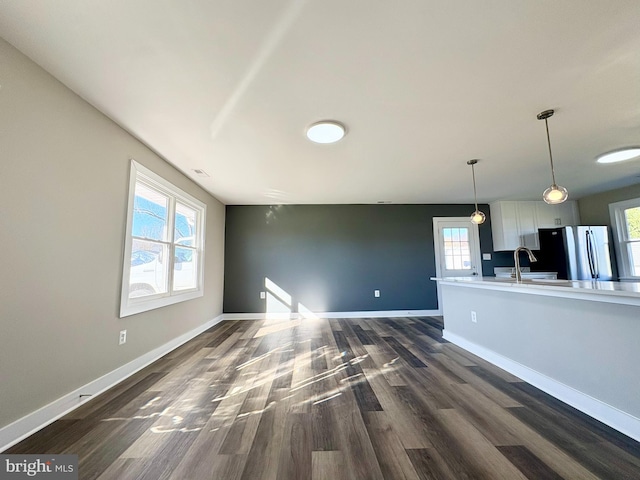 unfurnished living room with a wealth of natural light, sink, and dark hardwood / wood-style floors