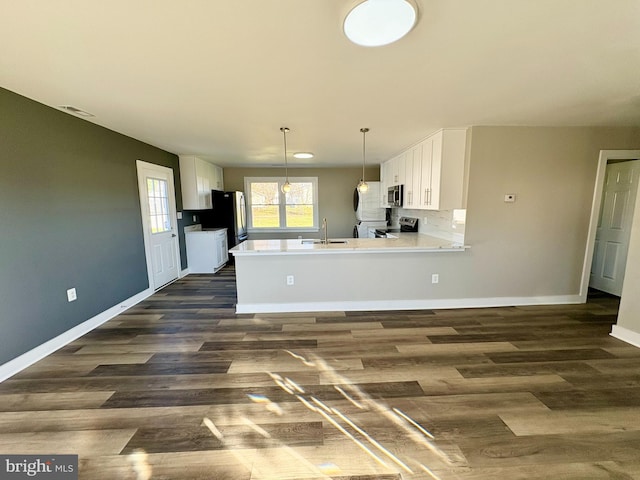 kitchen featuring white cabinetry, sink, stainless steel appliances, dark hardwood / wood-style flooring, and kitchen peninsula