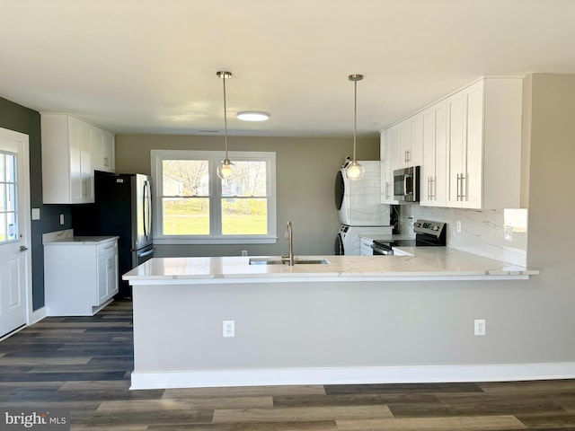 kitchen with kitchen peninsula, sink, dark wood-type flooring, and appliances with stainless steel finishes