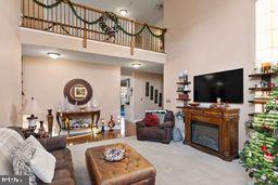 carpeted living room featuring a towering ceiling