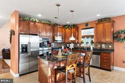 kitchen featuring a kitchen breakfast bar, a center island, decorative light fixtures, and appliances with stainless steel finishes