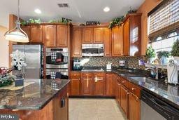 kitchen with pendant lighting, sink, tasteful backsplash, light tile patterned flooring, and stainless steel appliances