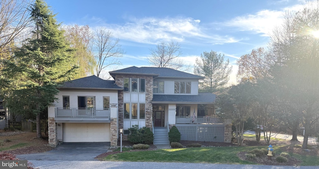 view of front of home featuring a porch, a garage, and a front lawn