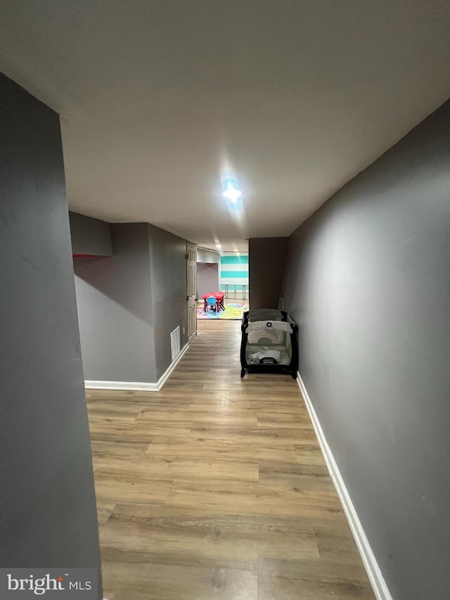 hallway with light hardwood / wood-style floors