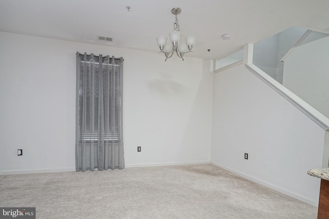 unfurnished room featuring light carpet and an inviting chandelier