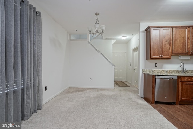 kitchen featuring pendant lighting, dishwasher, light carpet, and a chandelier