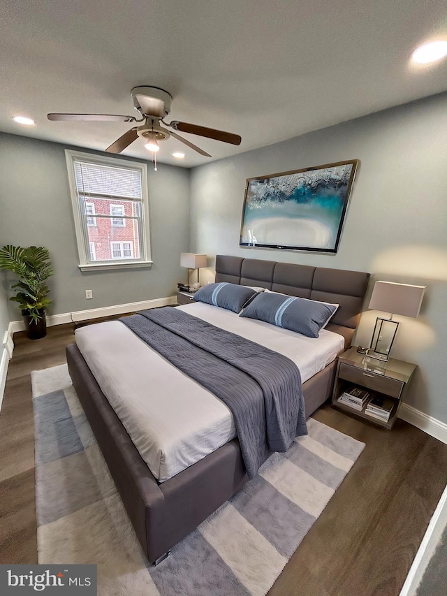 bedroom with dark hardwood / wood-style floors, ceiling fan, and a textured ceiling