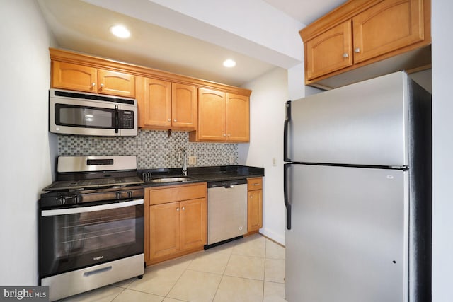 kitchen featuring light tile patterned flooring, sink, stainless steel appliances, and tasteful backsplash