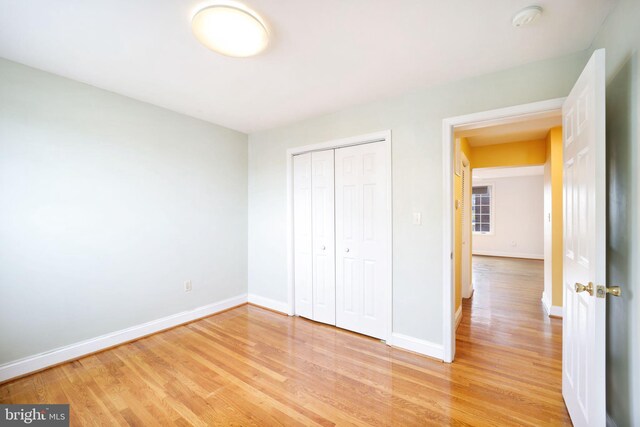 unfurnished bedroom featuring a closet and light hardwood / wood-style floors