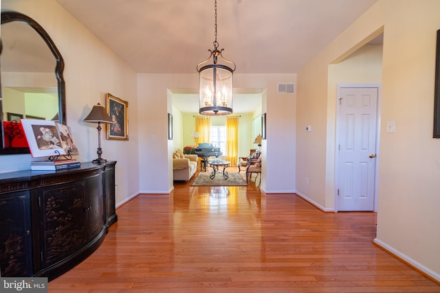 interior space with a notable chandelier and light wood-type flooring