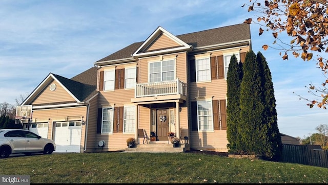 view of front facade featuring a balcony, a garage, and a front yard