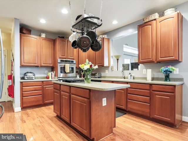 kitchen with a center island, oven, light wood-type flooring, and black stovetop