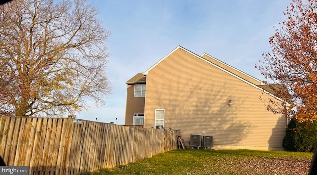 view of side of property with a yard and cooling unit