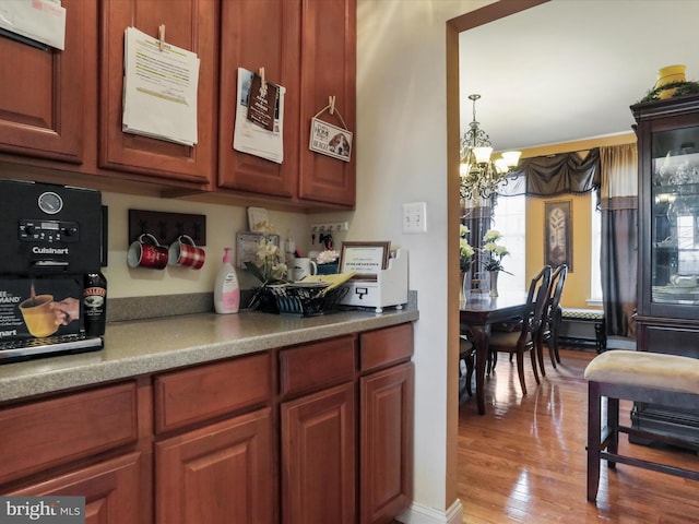 kitchen with hardwood / wood-style floors, hanging light fixtures, and a notable chandelier