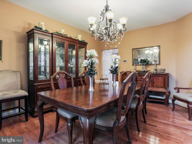 dining area featuring hardwood / wood-style flooring and a chandelier