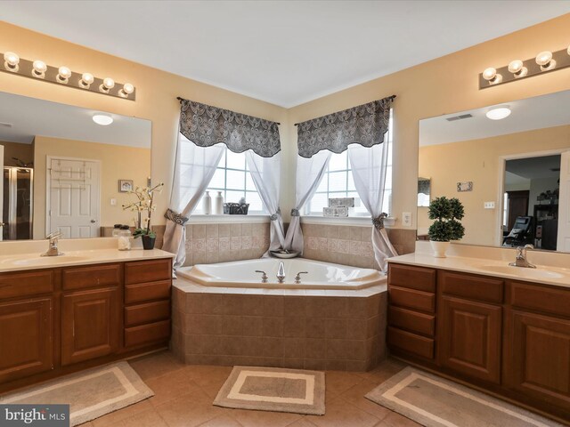 bathroom featuring tile patterned flooring, vanity, and shower with separate bathtub