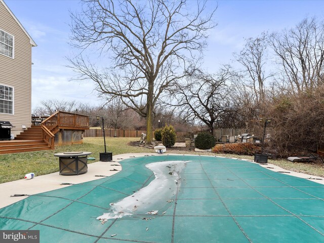 view of swimming pool with a wooden deck, an outdoor fire pit, and a patio area