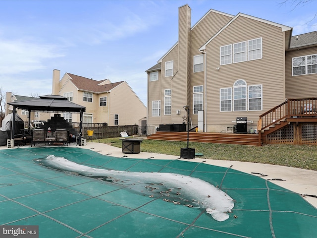 view of pool with a fire pit, a gazebo, and grilling area