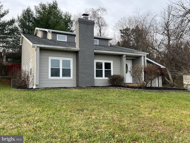 rear view of house featuring a lawn