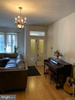 living room with hardwood / wood-style flooring and an inviting chandelier